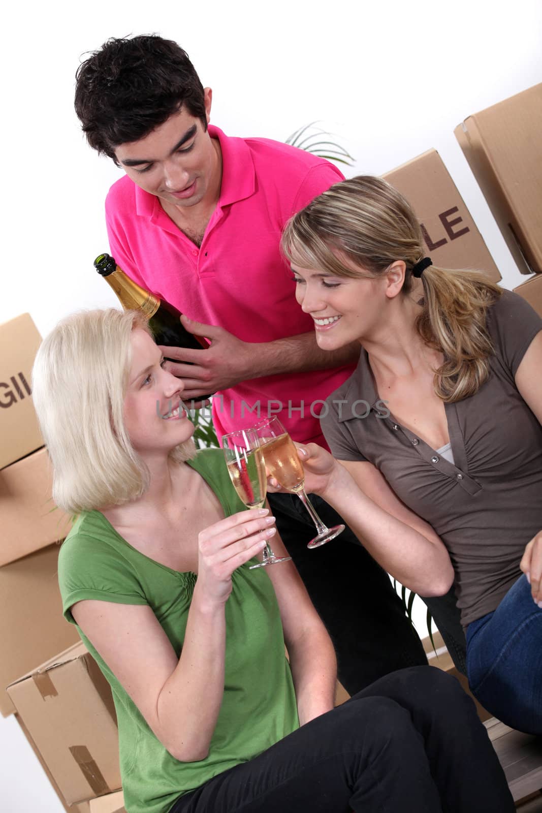 Three friends celebrating their moving out. by phovoir