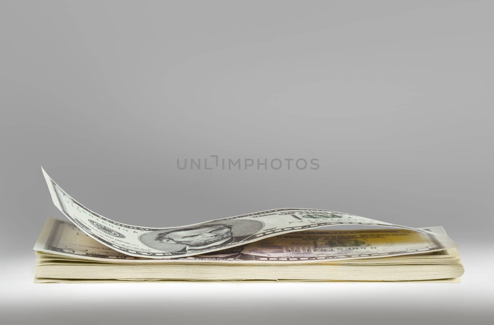 Stack of american dollars on grey background.