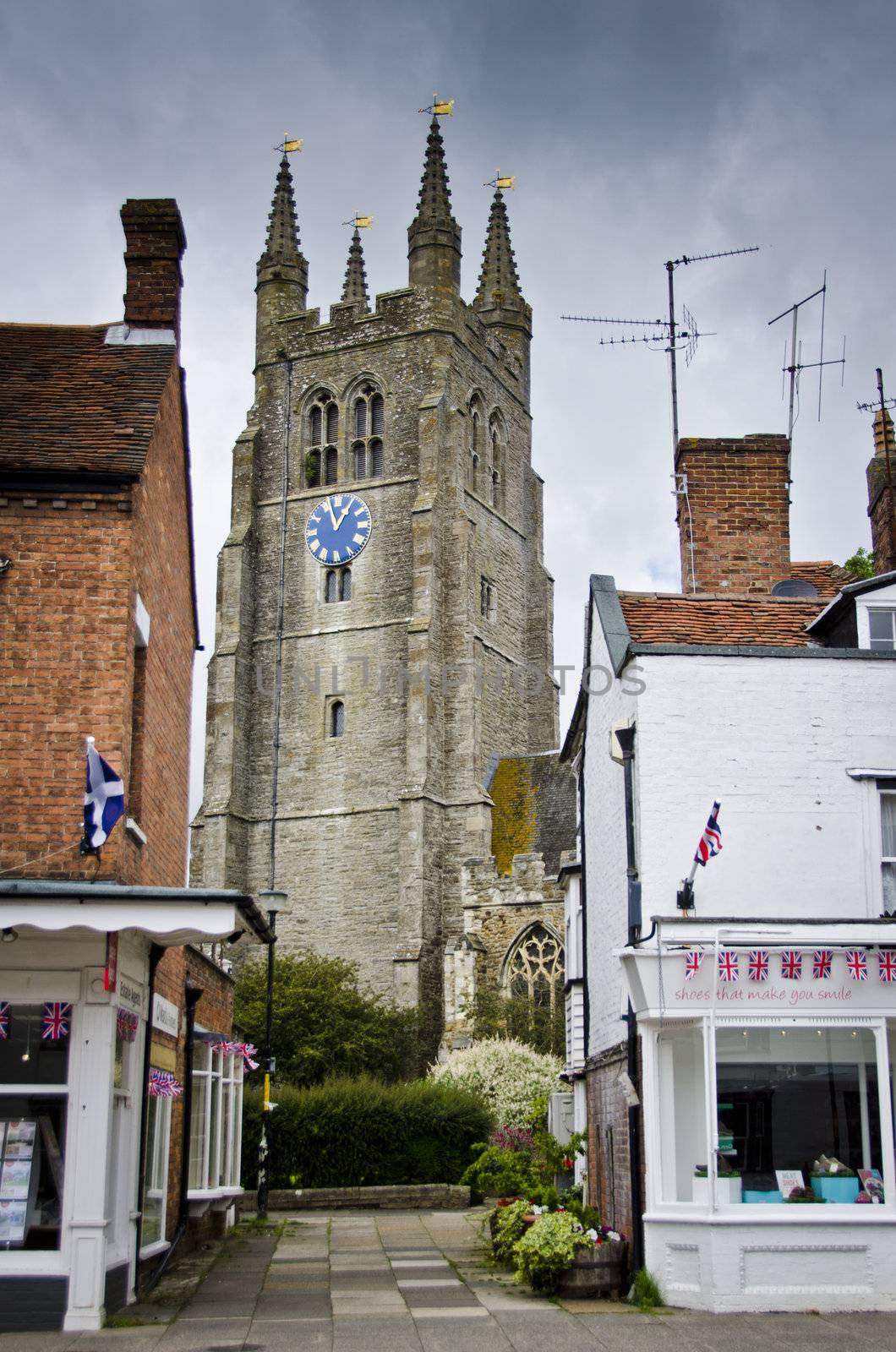 Tenterden church tower at the end of an alley between two shops