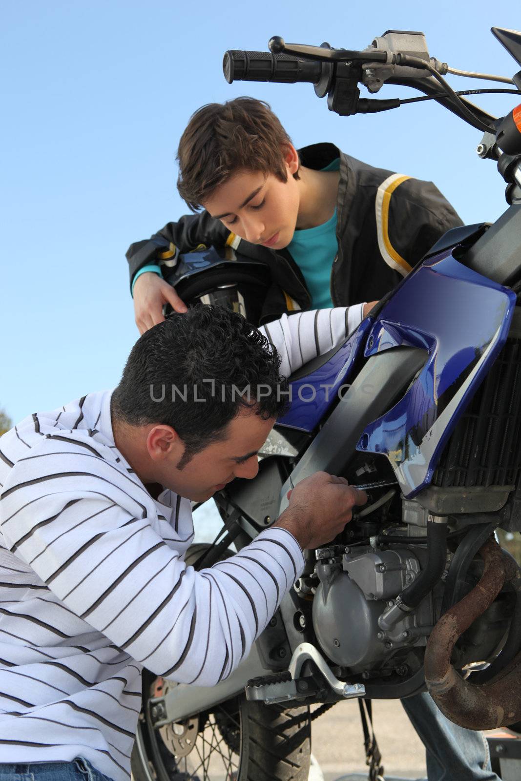 Father and son repairing their motorcycle