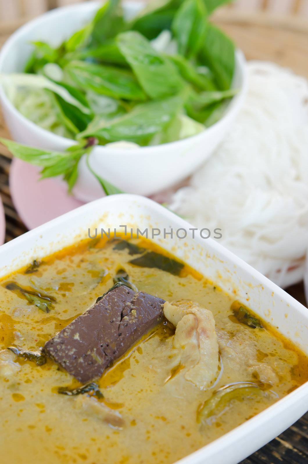 green chicken curry served with  rice vermicelli and fresh vegetable