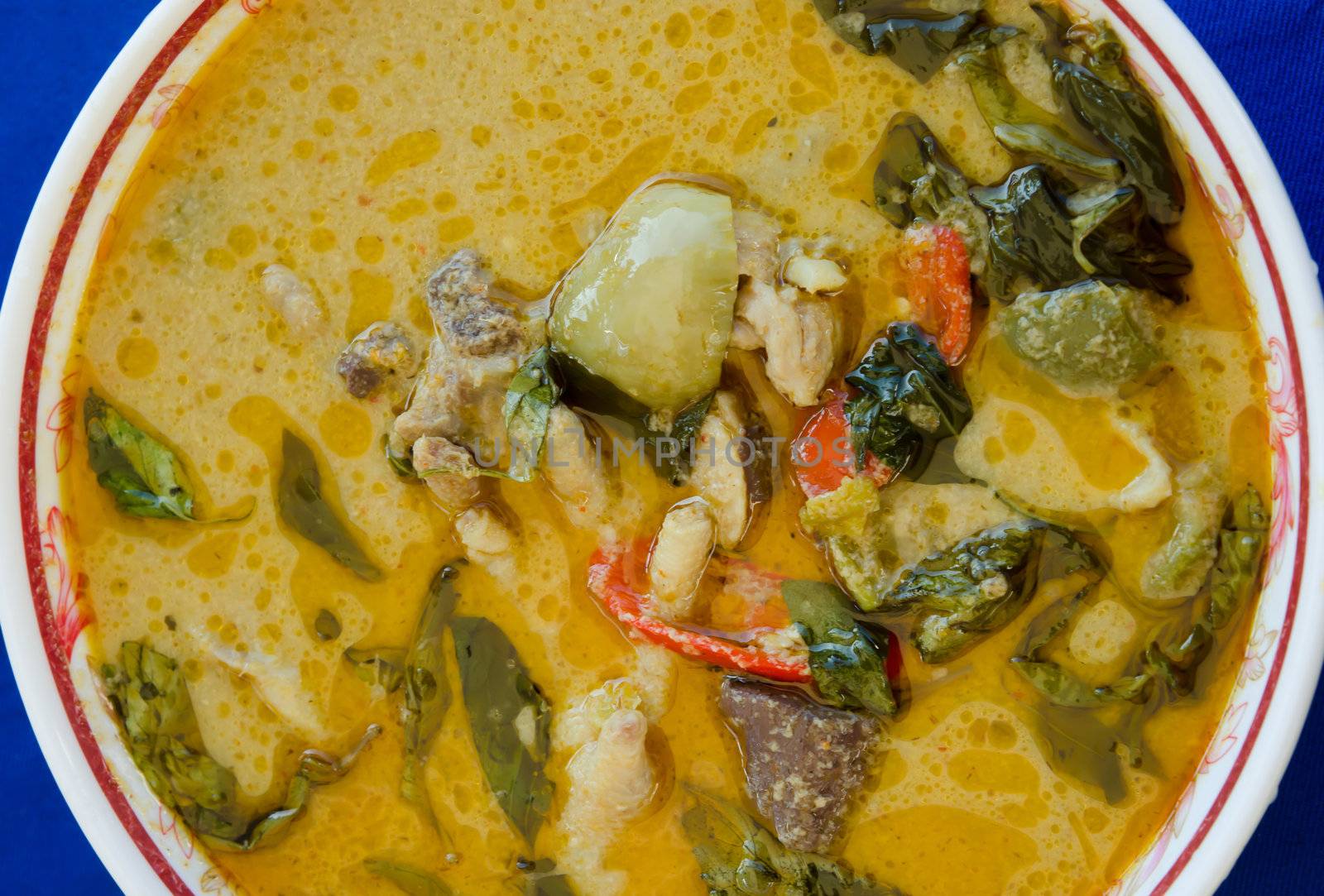 top view green chicken curry in bowl on blue background 