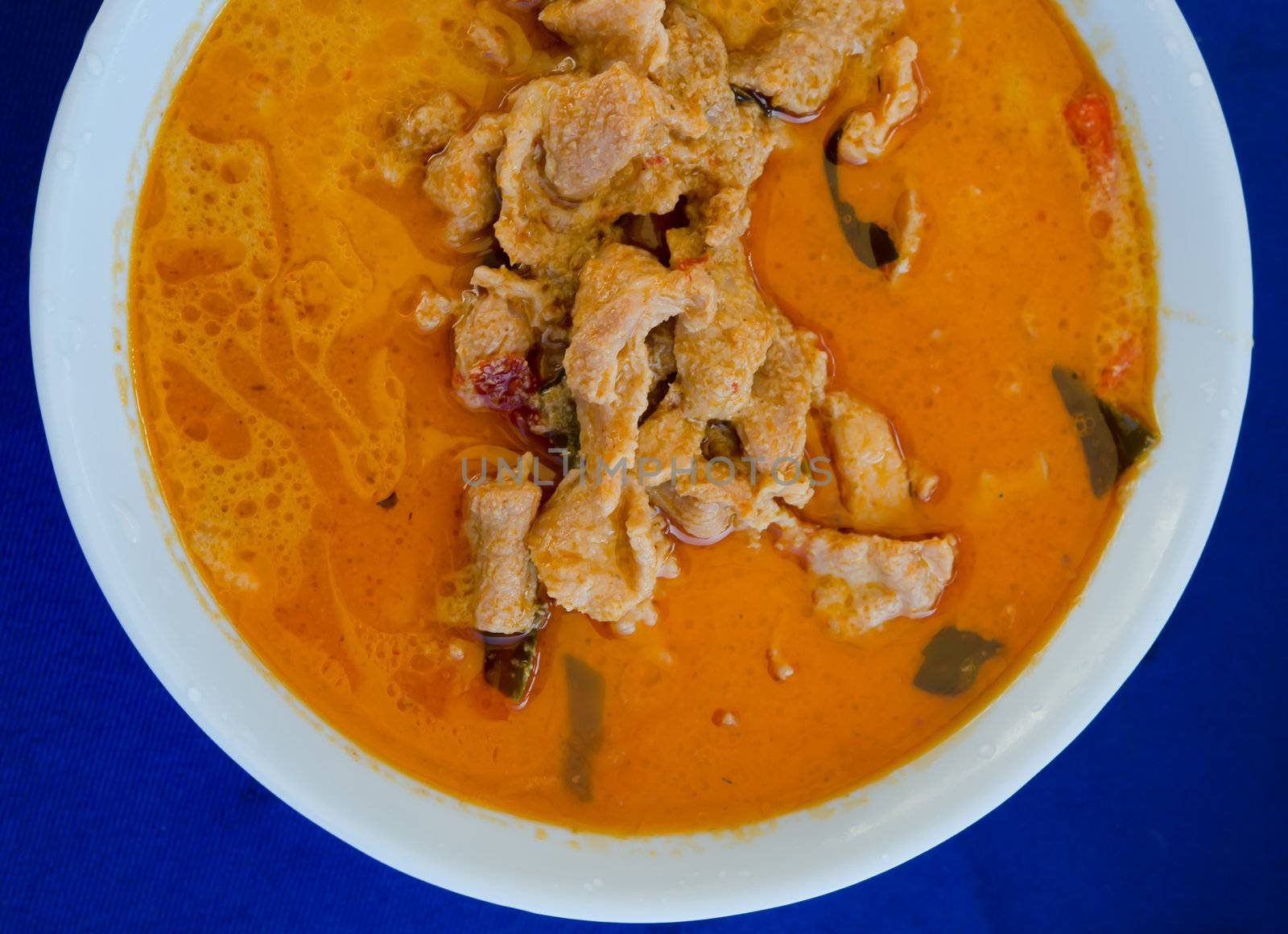  top view pork in ground peanut-coconut cream curry  on blue background