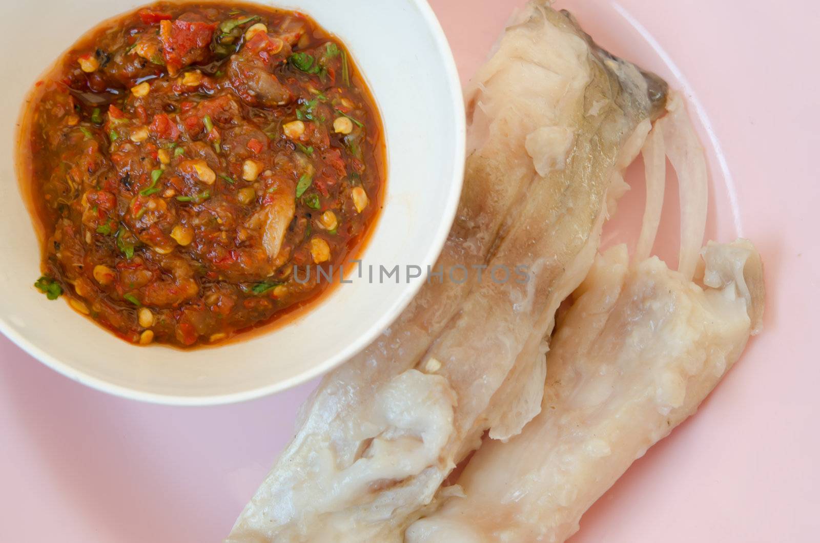 top view chili sauce and  fresh steam fish on pink dish