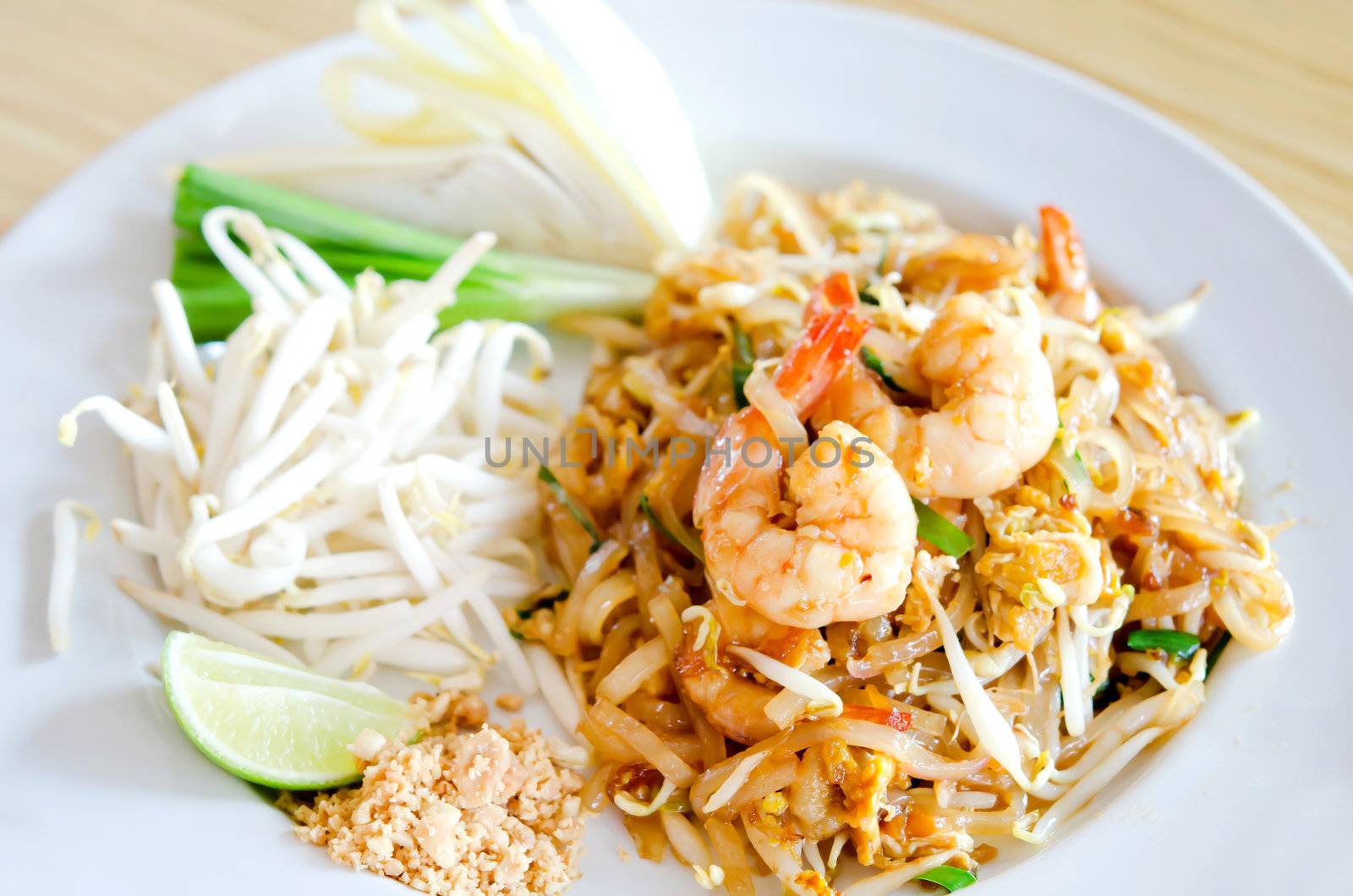 Stir fry noodles with shrimp , egg  and fresh vegetable on white dish