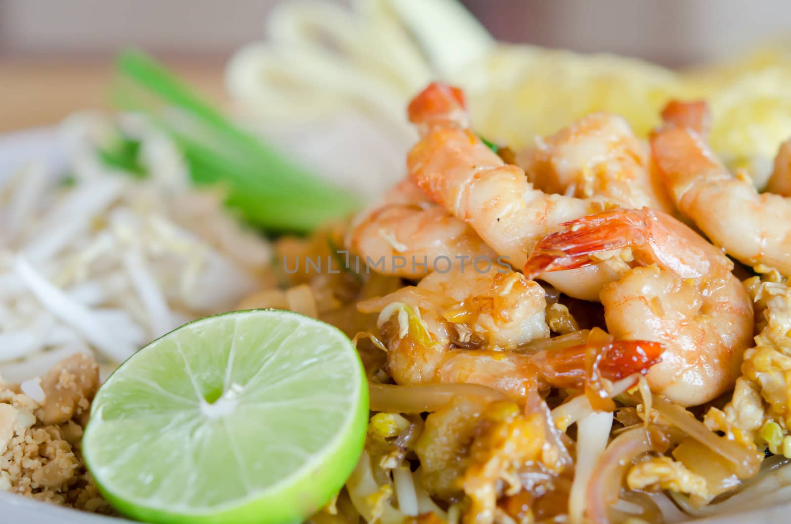 Stir fry noodles with shrimp , egg  and  vegetable served with fresh lemon and fresh vegetable
