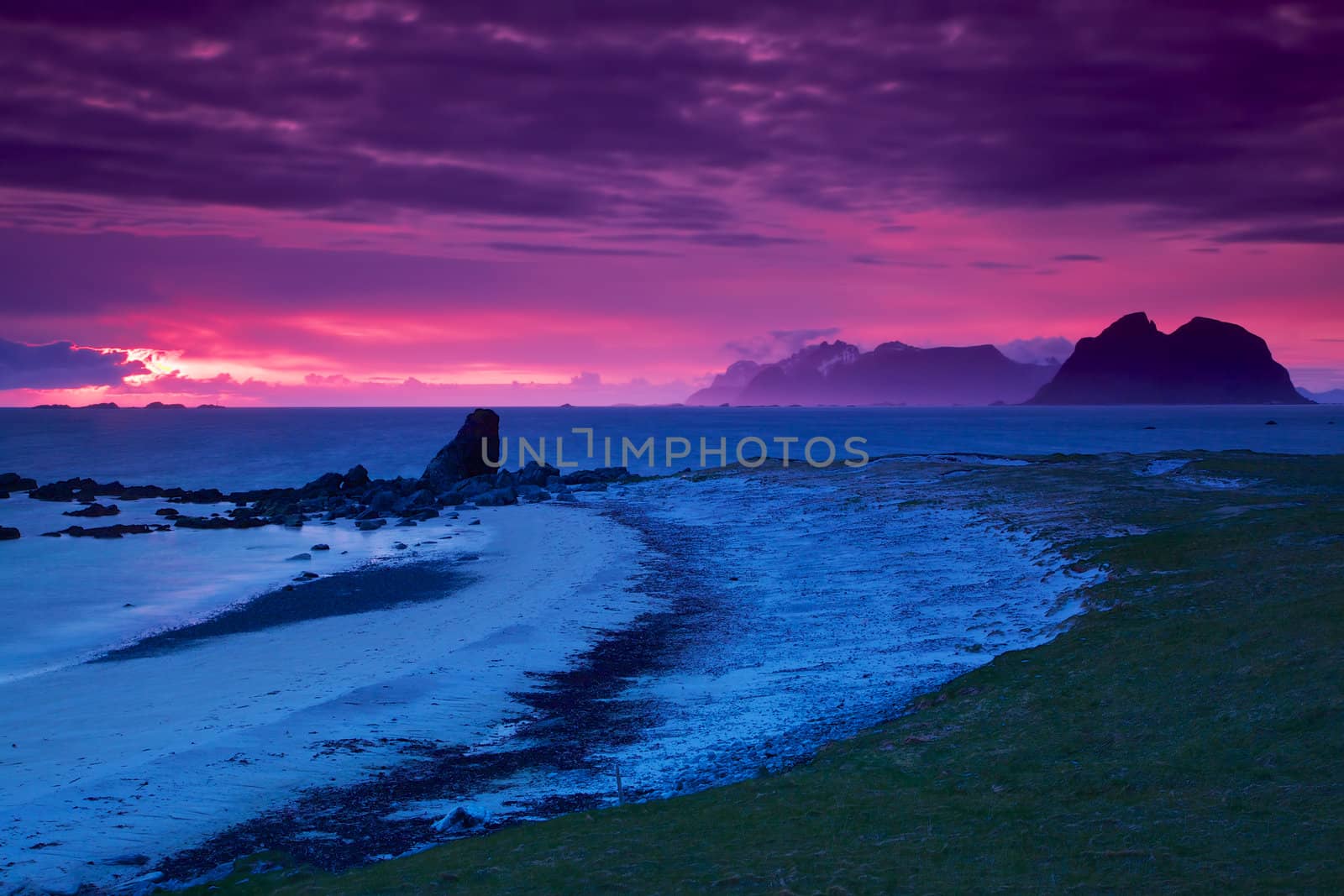 Picturesque panorama of white sand beach lit by midnight sun on Lofoten islands in Norway
