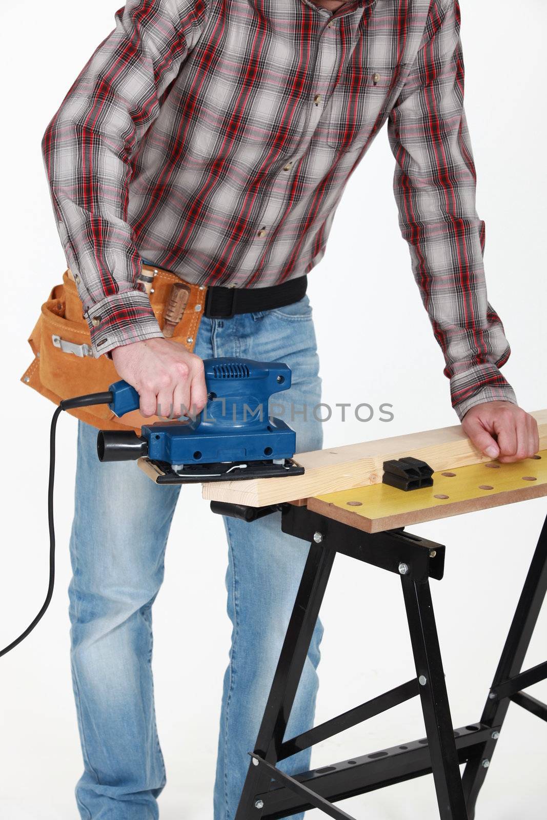 carpenter at work with sander machine by phovoir
