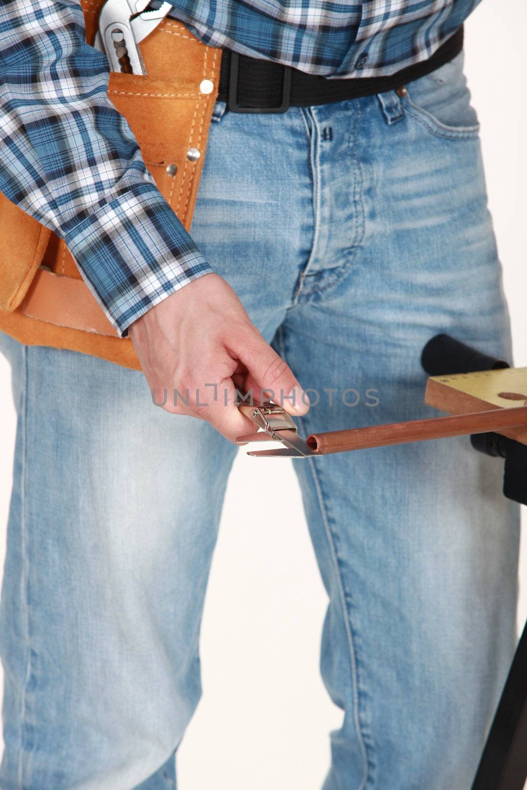 Tradesman using a vernier scale to measure a copper tube by phovoir