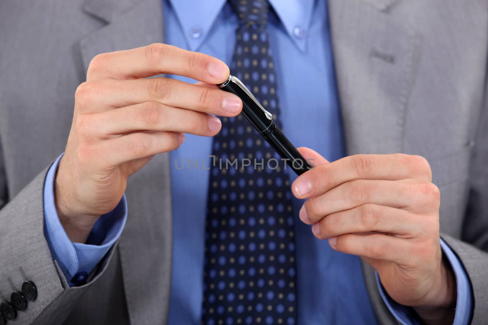 Businessman displaying pen by phovoir