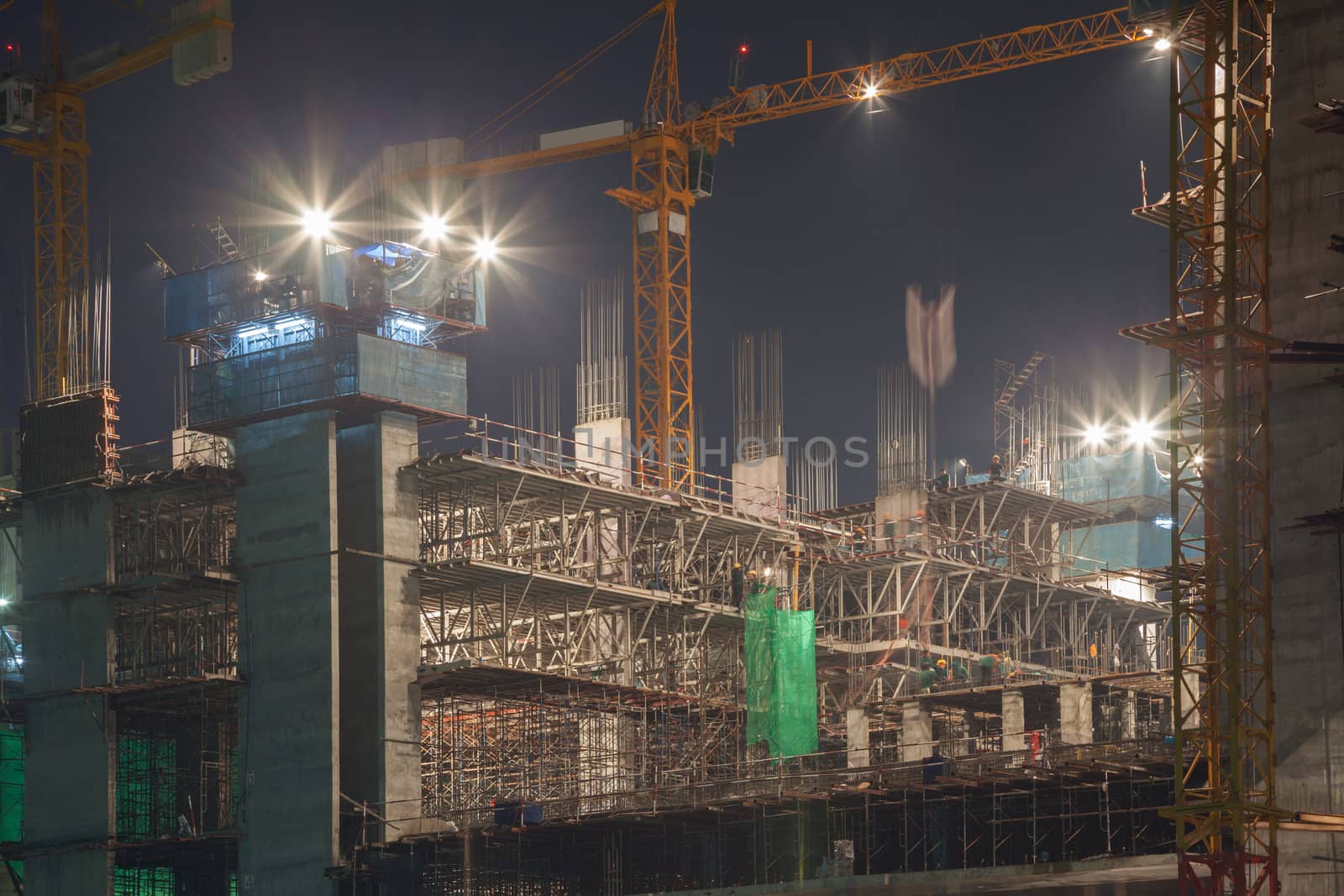 construction site with moving crane at dusk