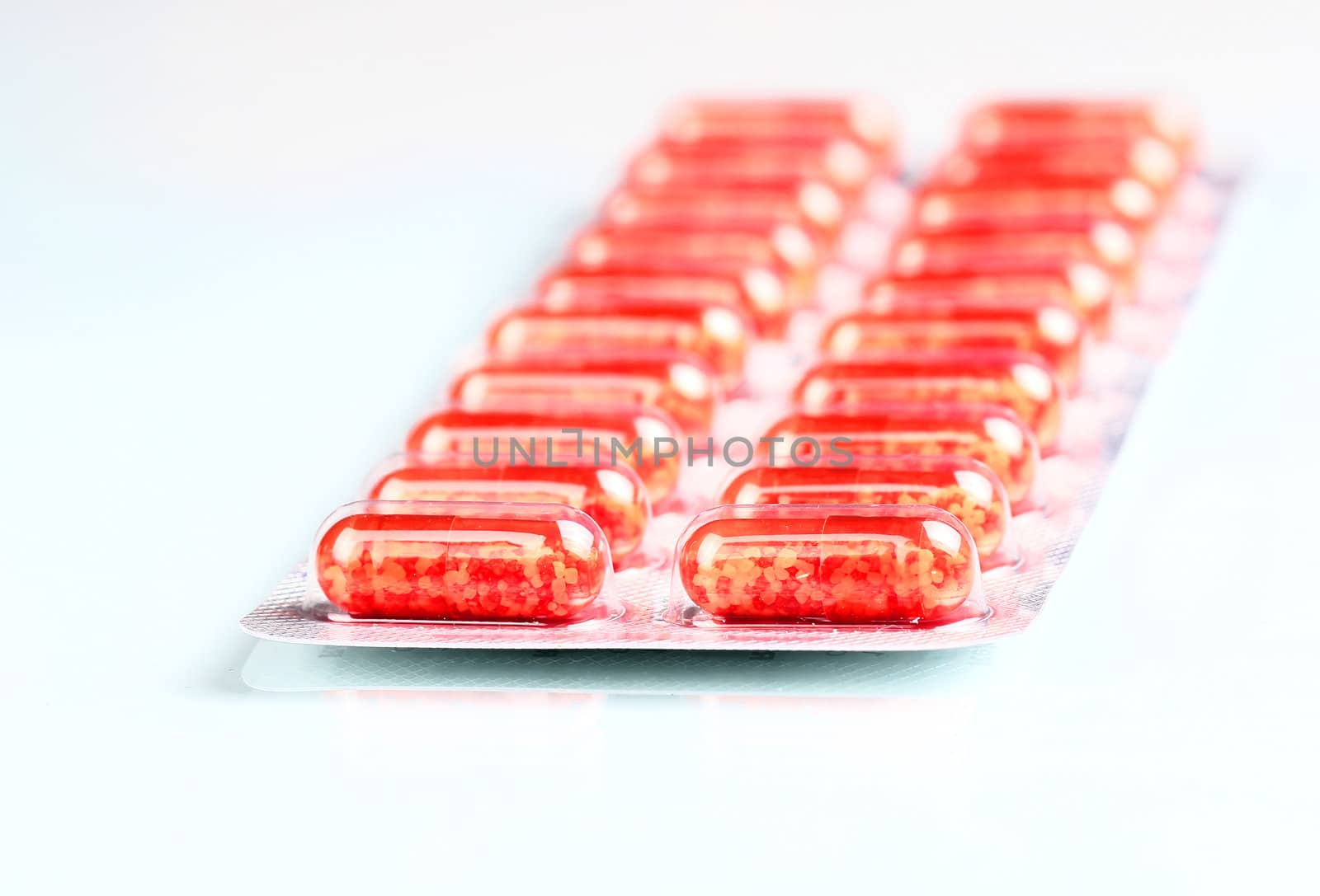 Pack of red pills isolated. Medical background