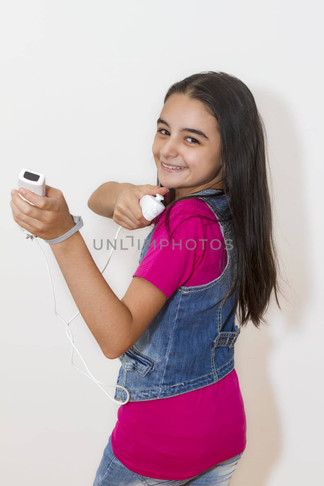 Young teenage girl playing video games with a Nintendo Wii controller (gamepad). by manaemedia