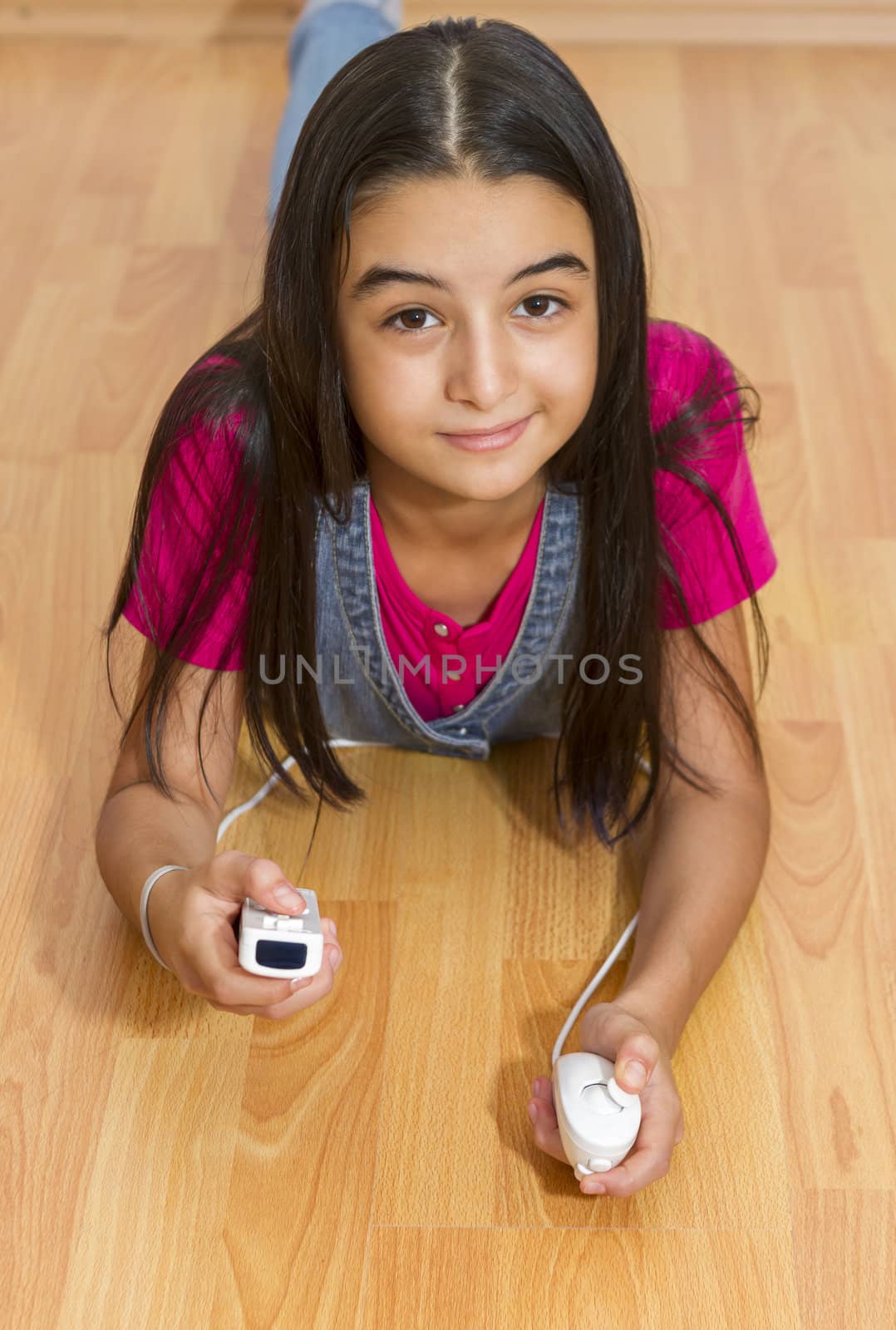 Young teenage girl playing video games with a Nintendo Wii controller (gamepad). by manaemedia