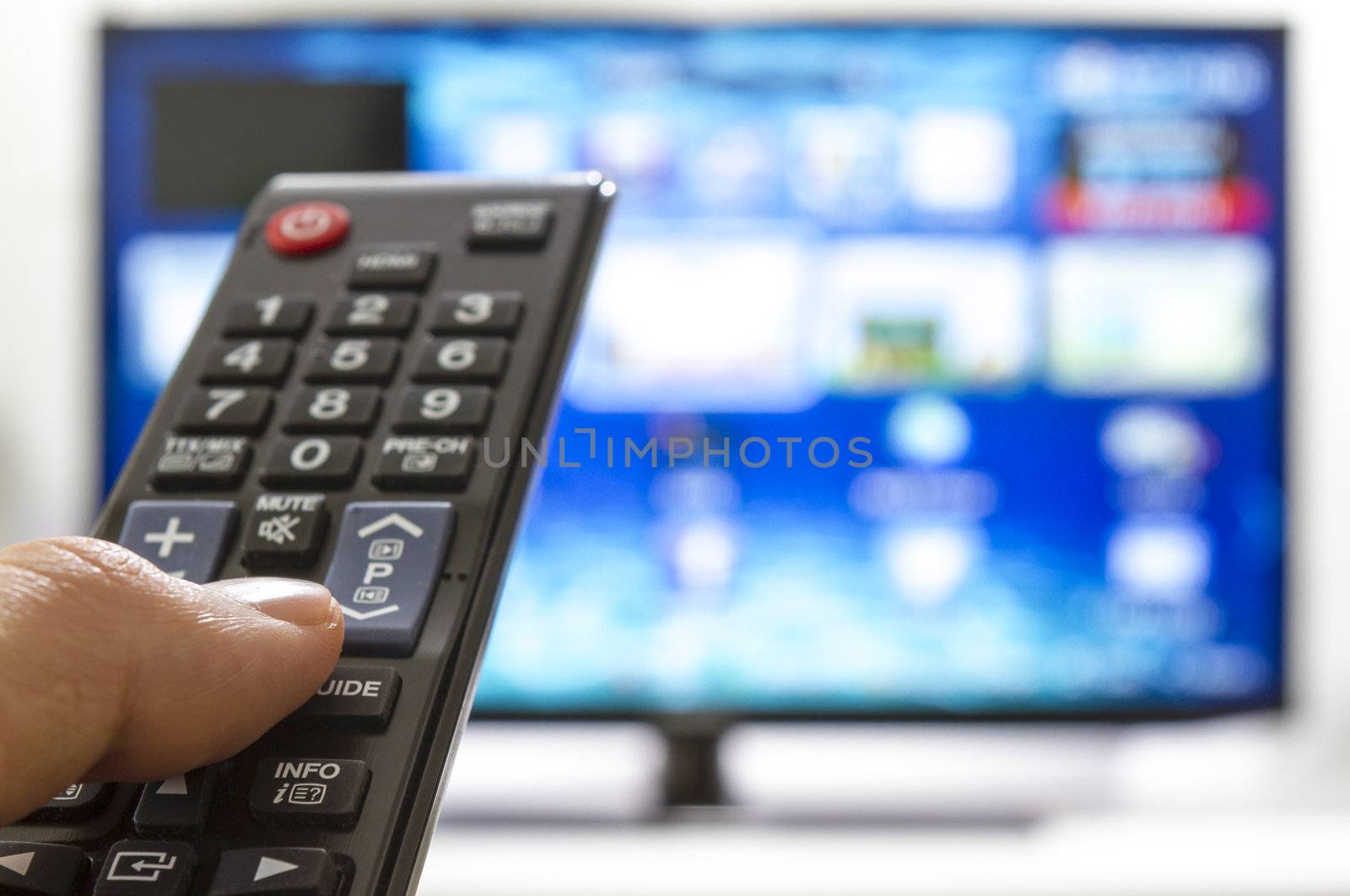 Smart tv and hand pressing remote control by manaemedia