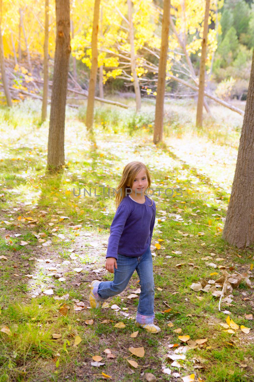Autumn kid girl running poplar tree forest motion blur in nature outdoor