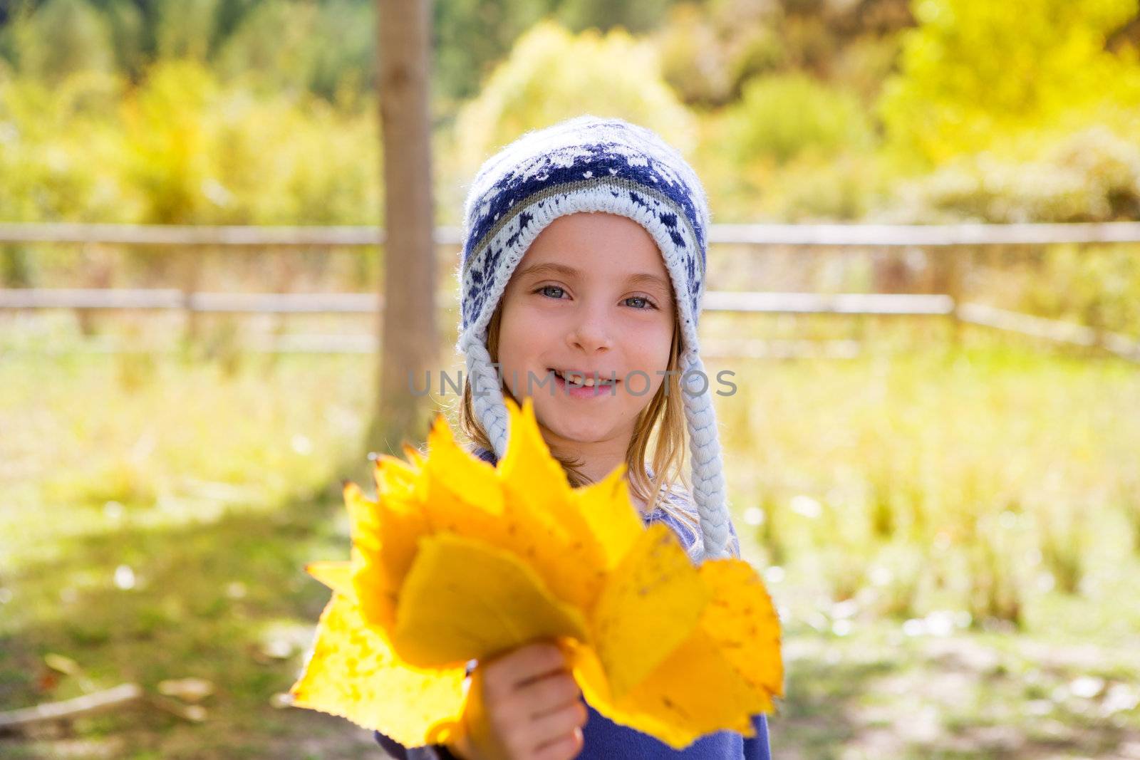 Child girl in autumn poplar forest yellow fall leaves in hand by lunamarina