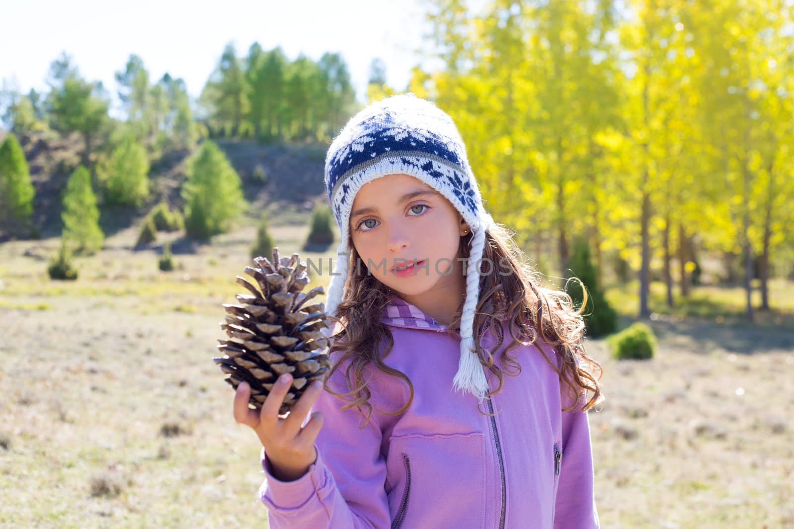 Child little girl holding pine cone in winter fall by lunamarina