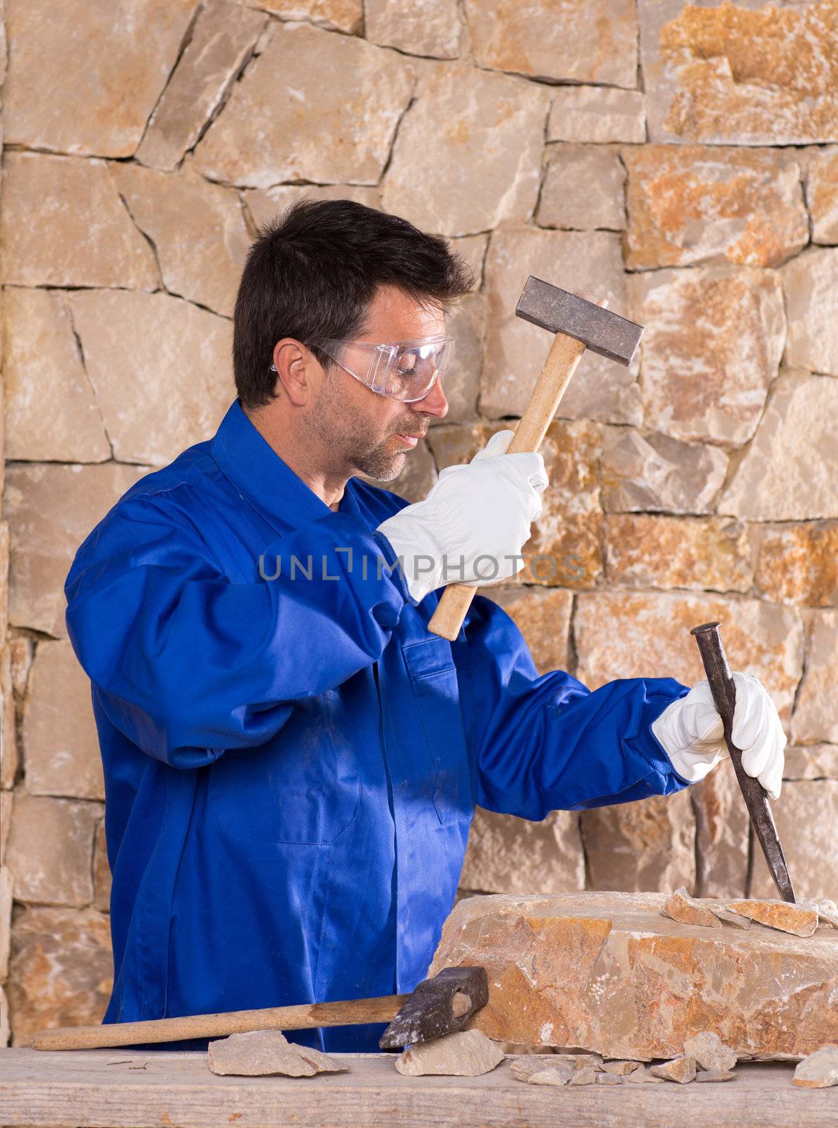 Masonry mason stonecutter man with hammer working by lunamarina