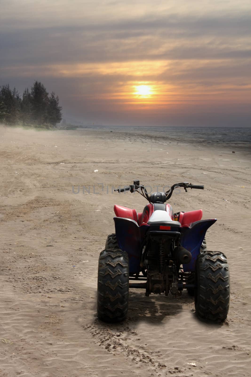 A beach buggy bike on the sand at a beautiful beach at sunset.