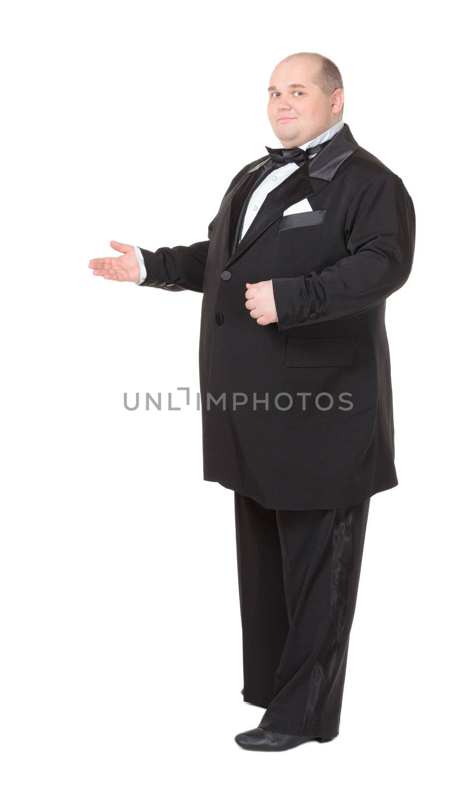 Elegant fat man in a dinner jacket and bow tie smiling charmingly as he holds out his hand to the side gesturing in that direction