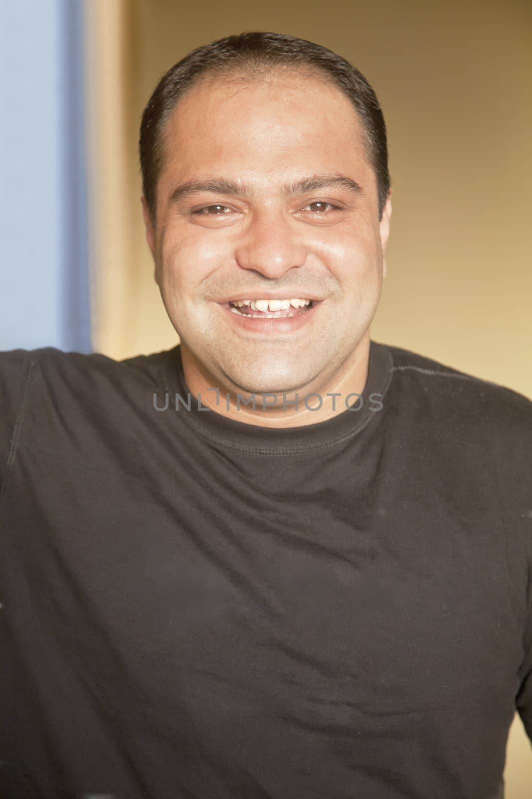 Vertical close up of a smiling happy asian young man with plain black T shirt, well groomed, receding hairline