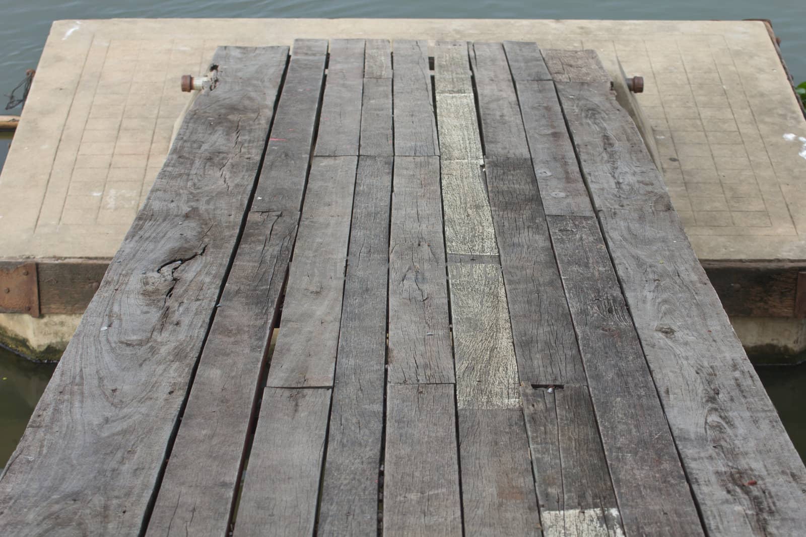Wooden bridge spanning the river to the pontoon