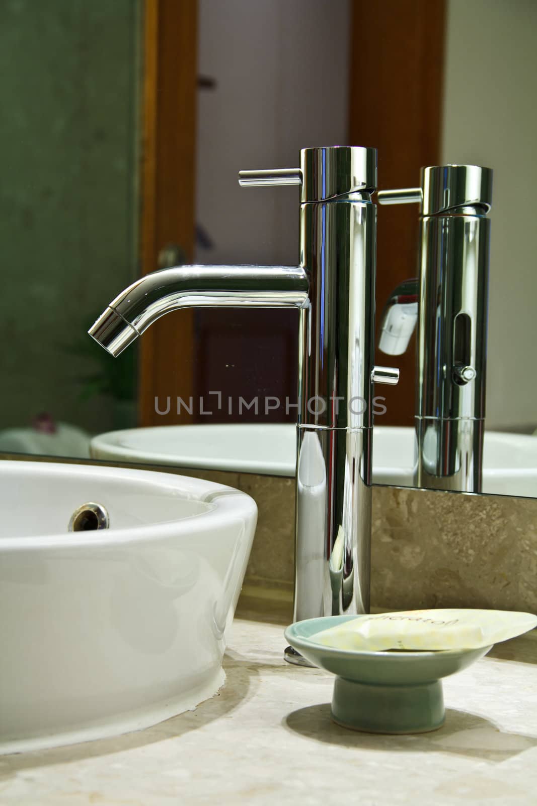 Silver chrome bathroom tap faucets running water in a sink