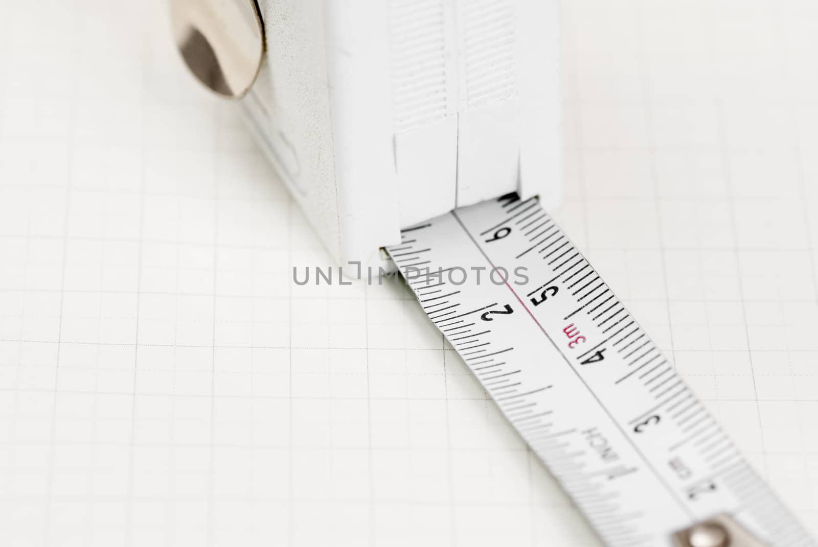 White tape measure on graph paper.