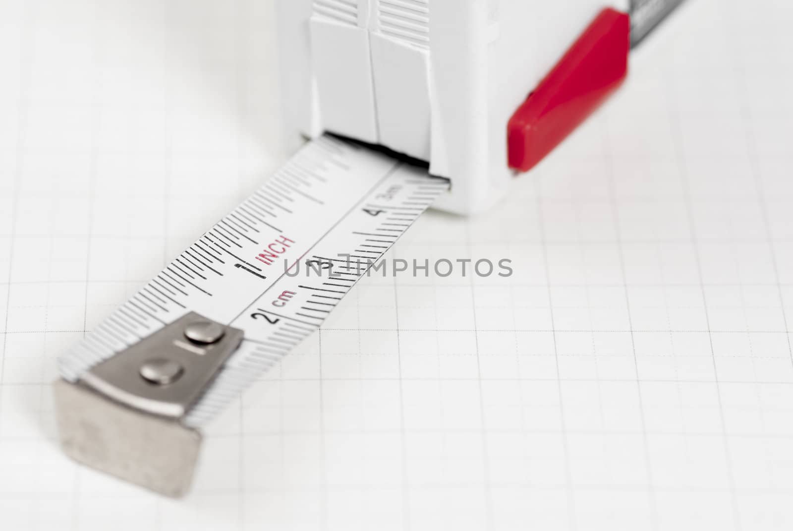 White tape measure on graph paper.