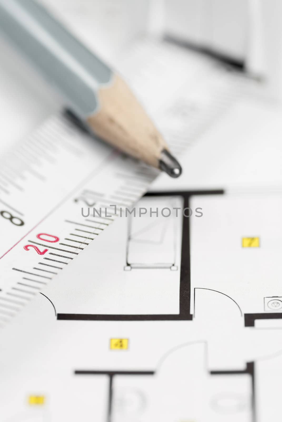 White tape measure on architect plans with pencil.