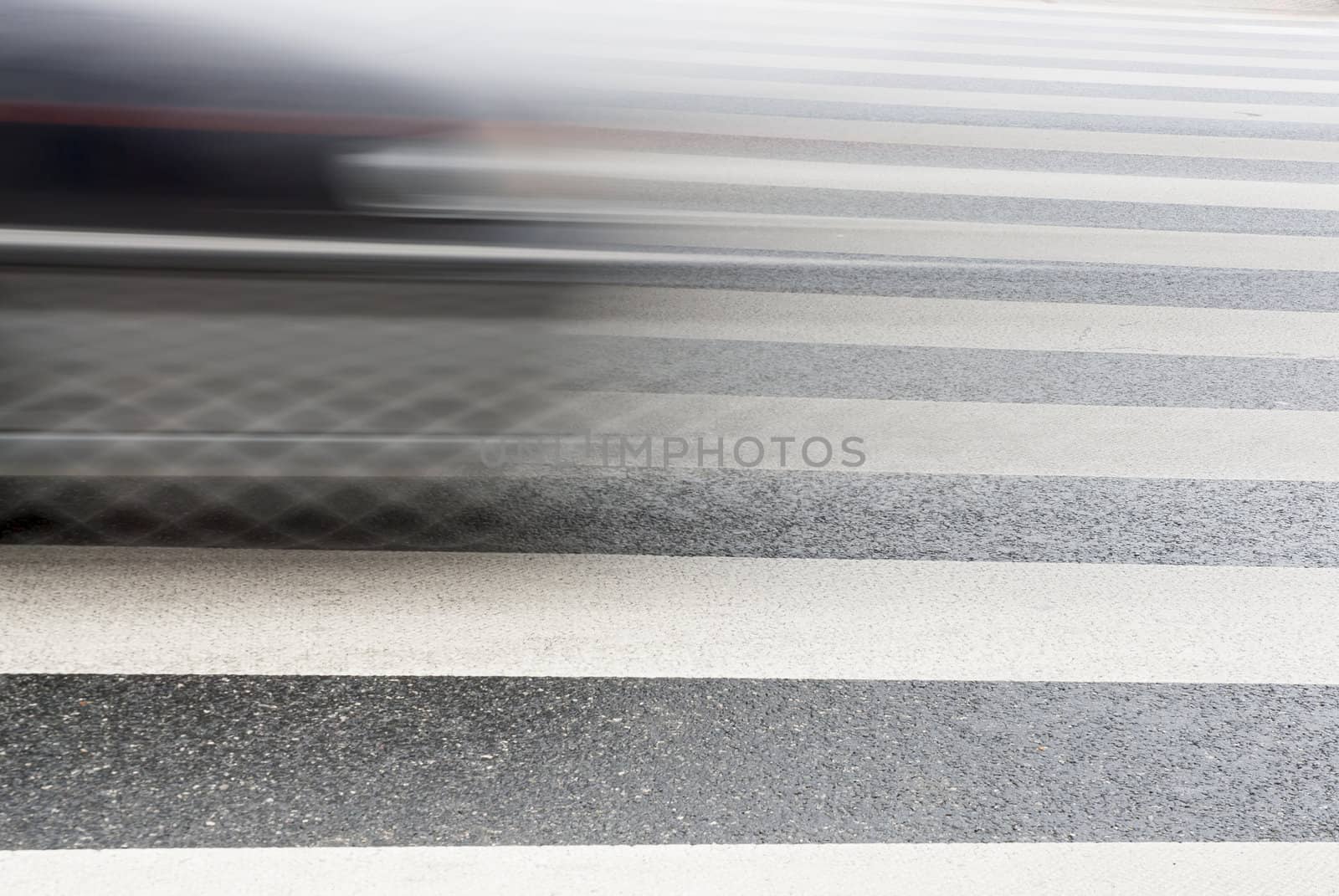 Detail of a Car speeding over a pedestrian crossing.