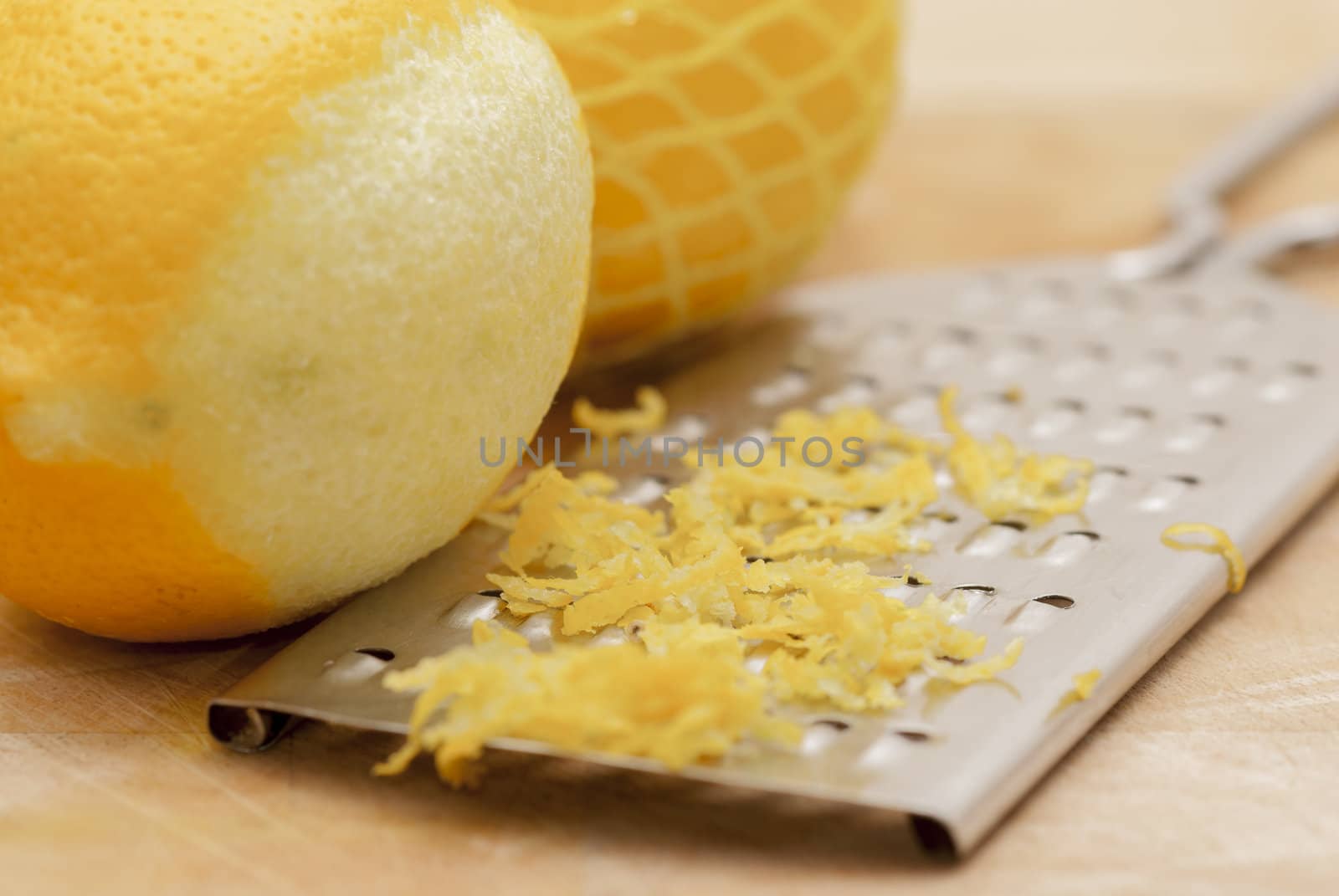 Zested lemons on wooden chopping board.