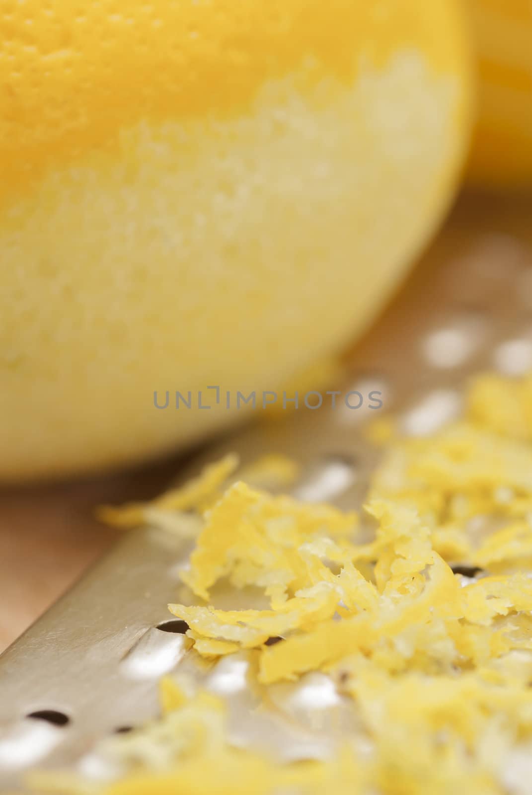 Zested lemons on wooden chopping board.