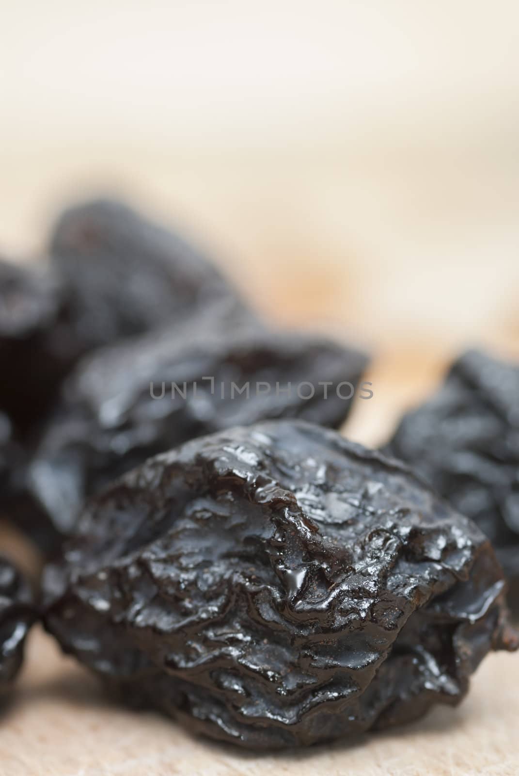 Macro photo of prunes on wooden chopping board.