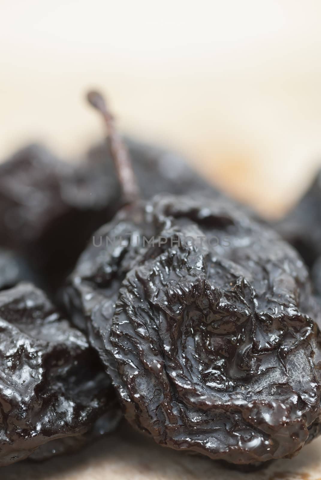 Macro photo of prunes on wooden chopping board.