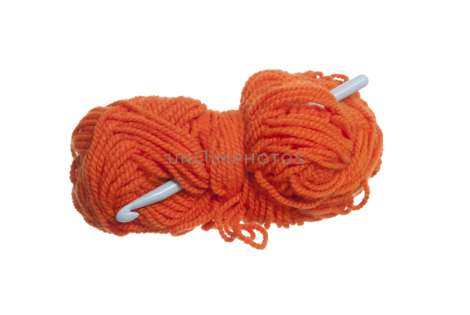 Orange wool and crochet hook on white background.