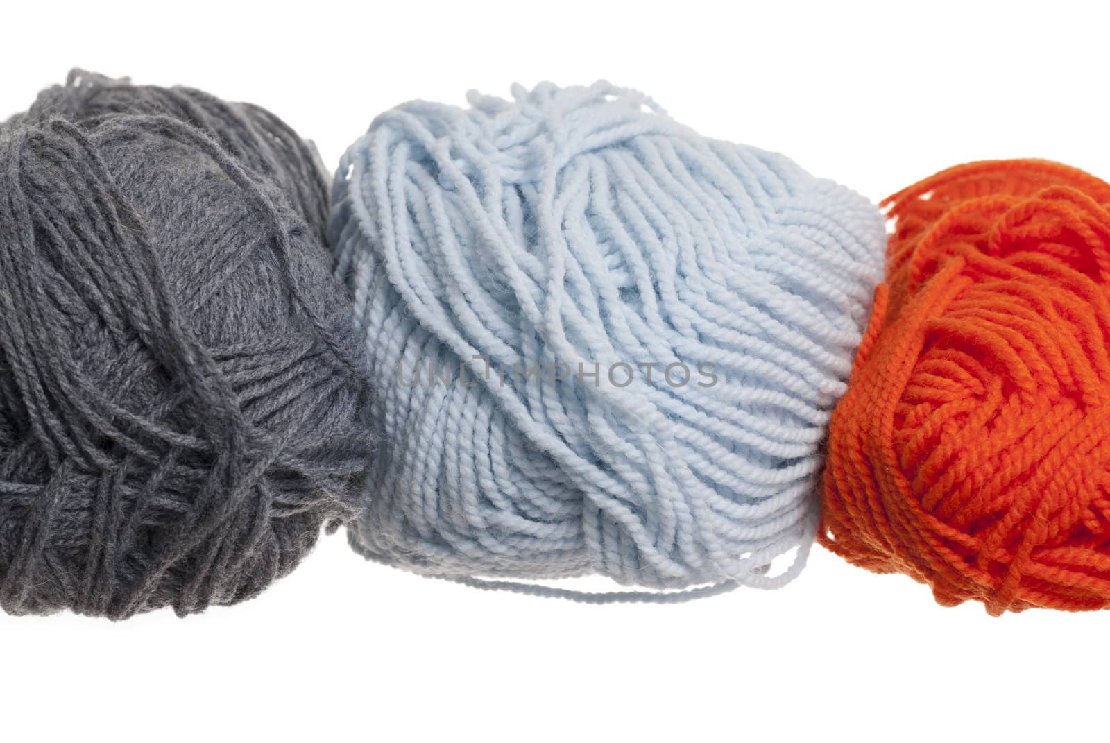Multi-Coloured knitting wool, white background.