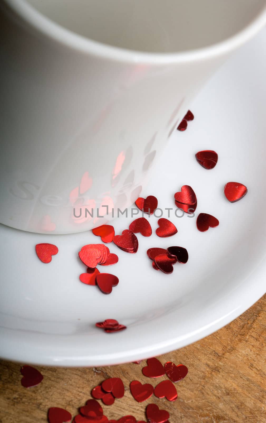 Coffee cup with glitter hearts on a old wooden table