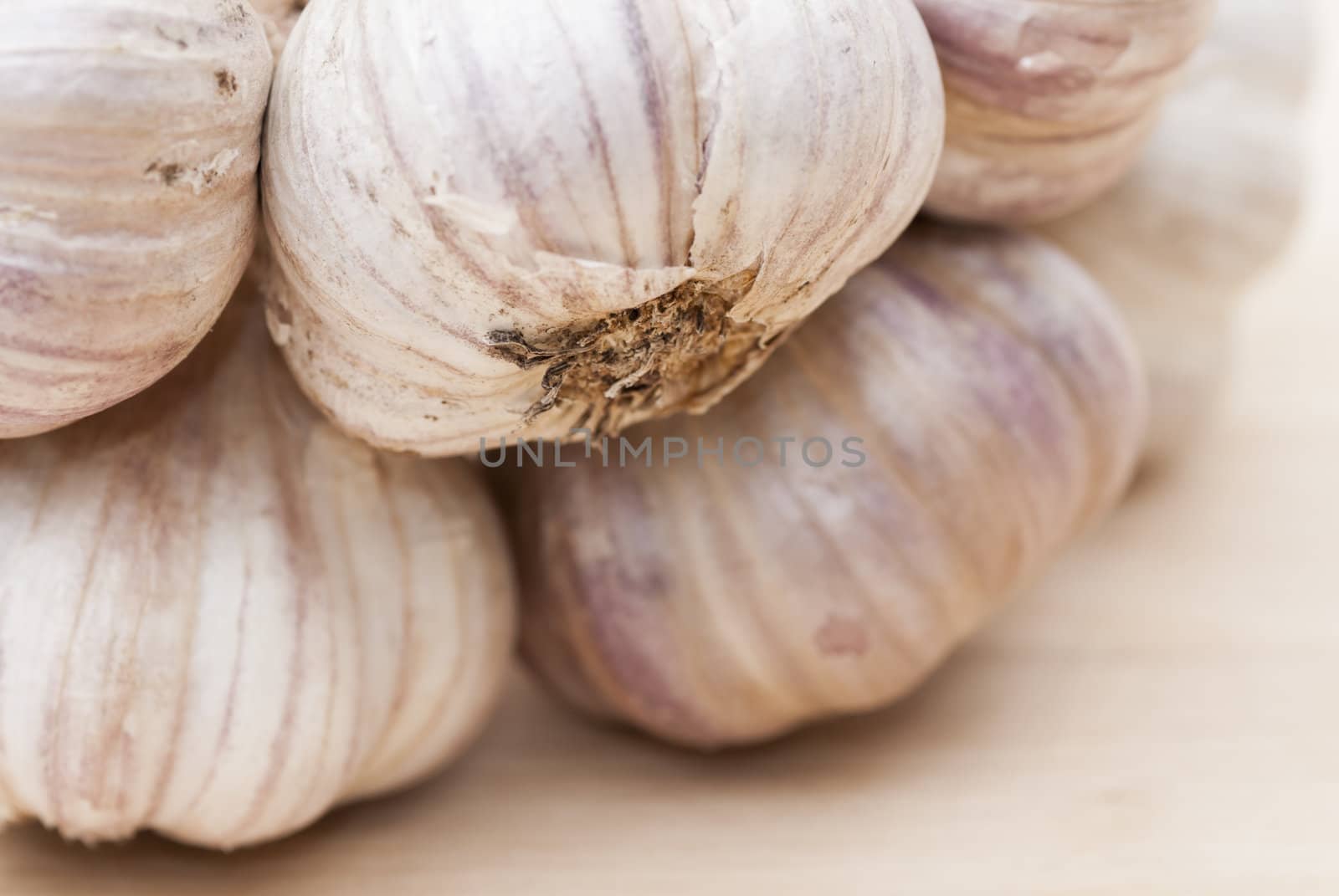 Macro image of garlic against wooden background.