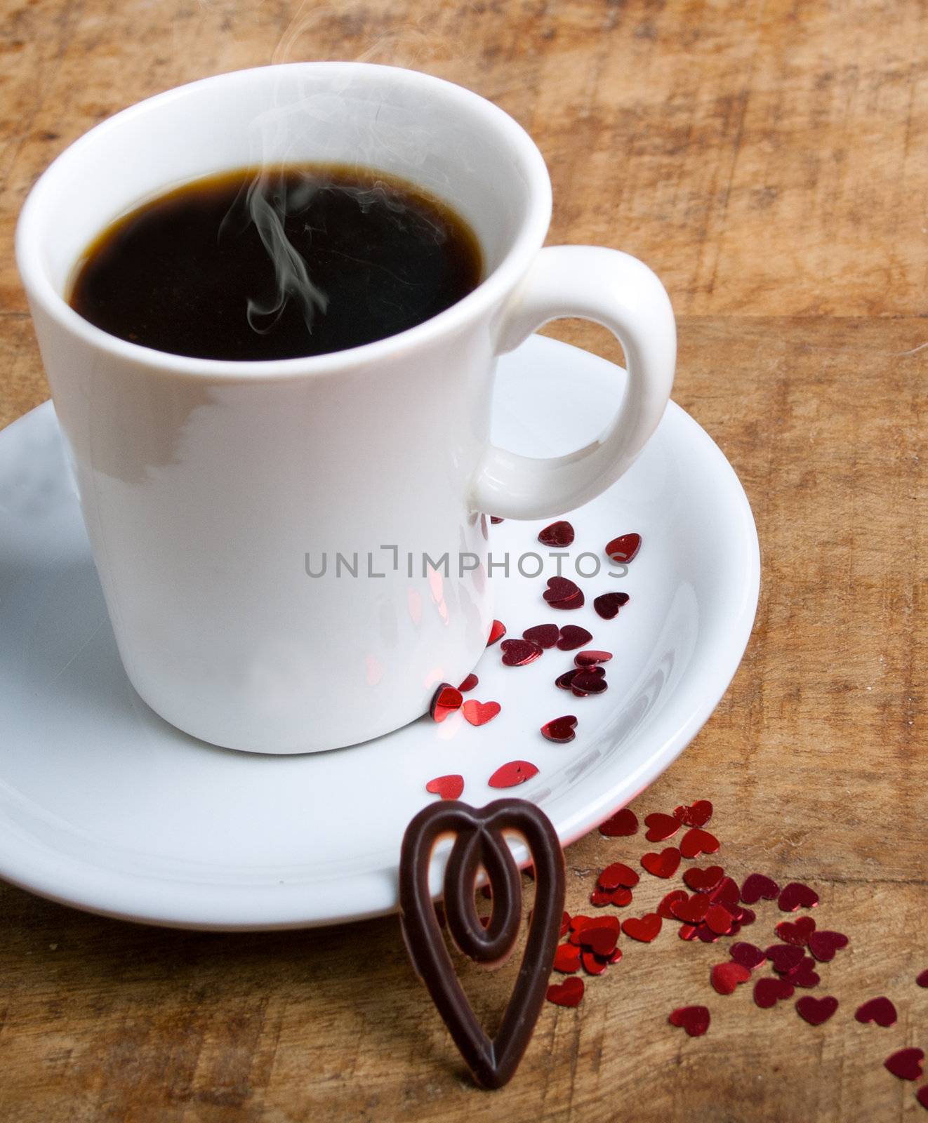 Coffee cup with glitter hearts on a old wooden table