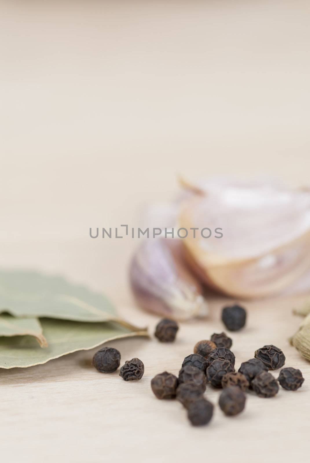 Garlic, Peppercorns, Bay Leaves on wooden kitchen surface