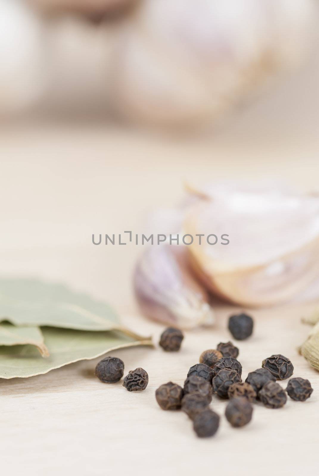 Garlic, Peppercorns, Bay Leaves on wooden kitchen surface