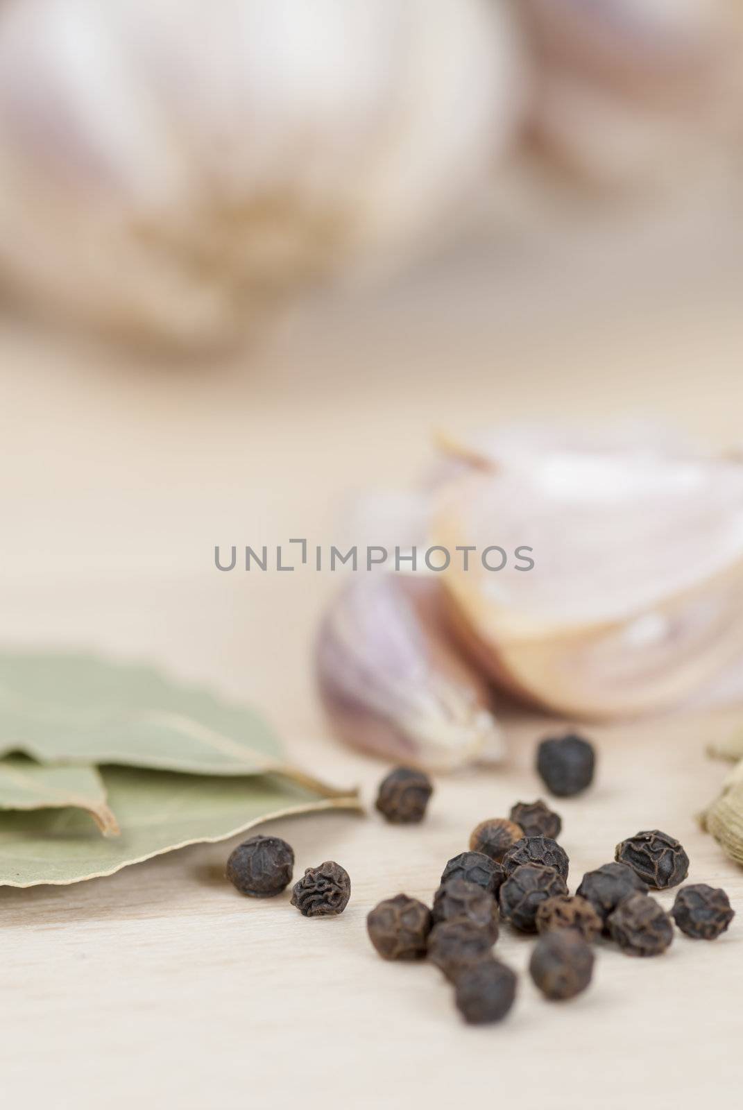 Garlic, Peppercorns, Bay Leaves on wooden kitchen surface