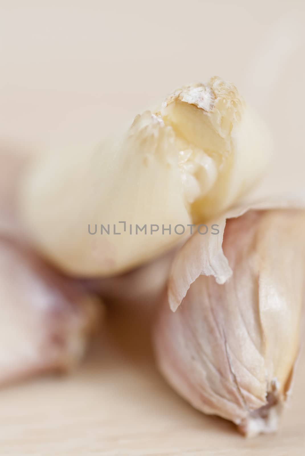 Garlic cloves on wooden surface; Macro.
