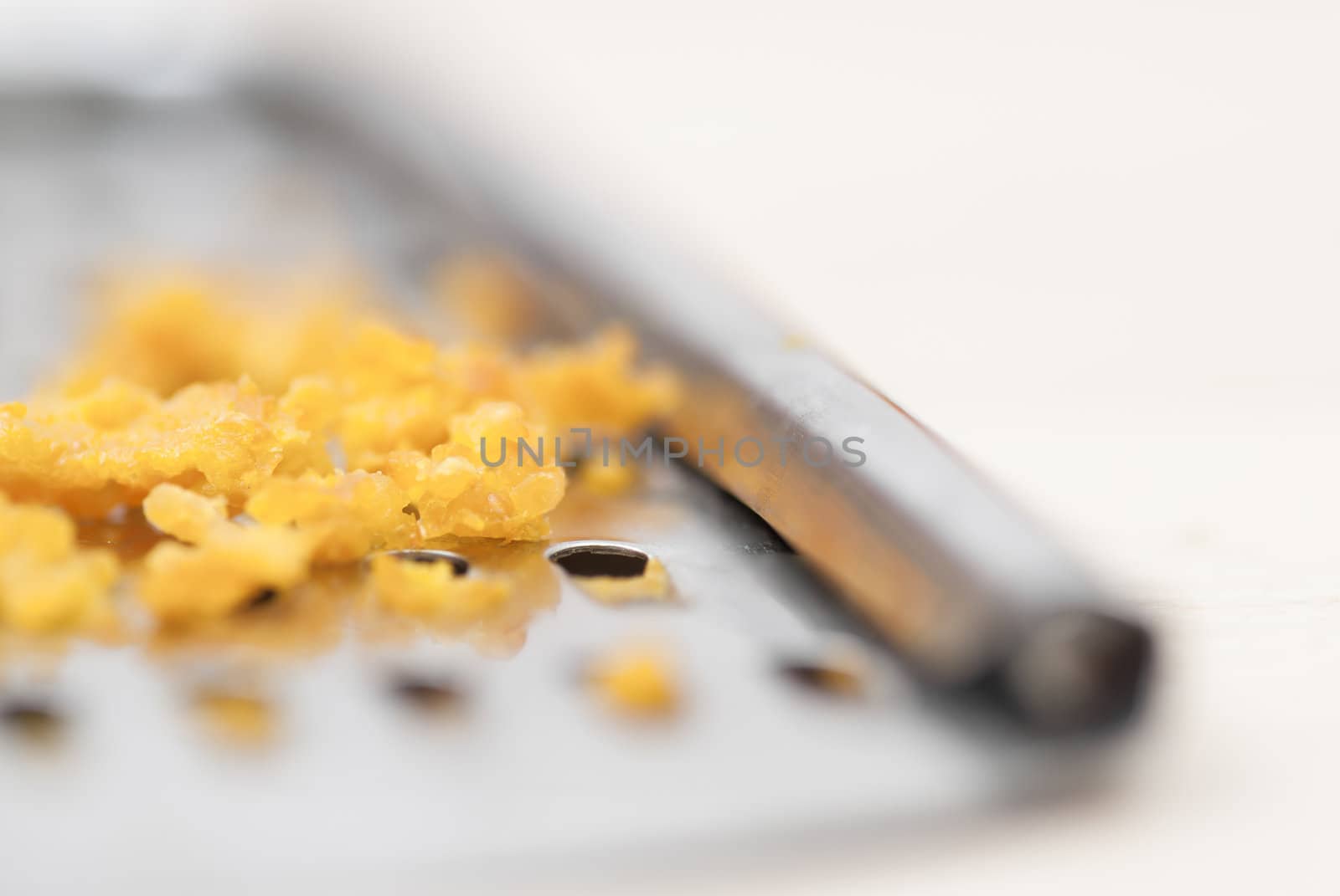 Grater and citrus zest on wooden kitchen surface.