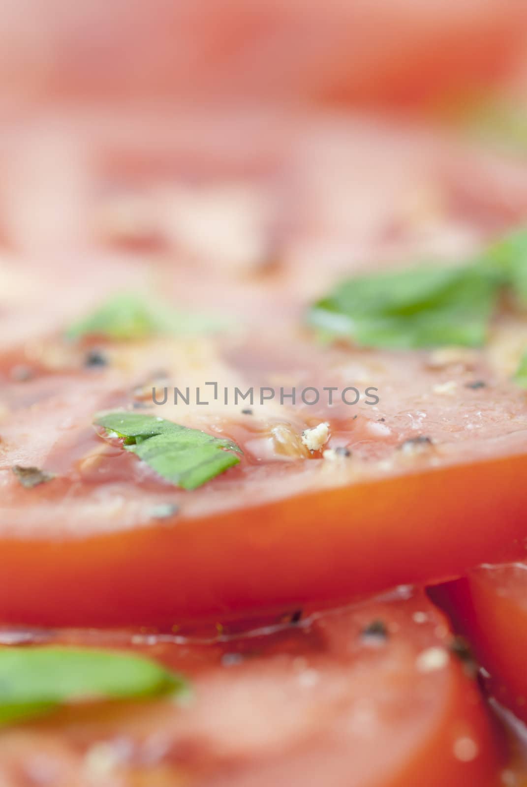 Macro image of slices of Tomato prepared with oilive oil, basil, pepper & salt.