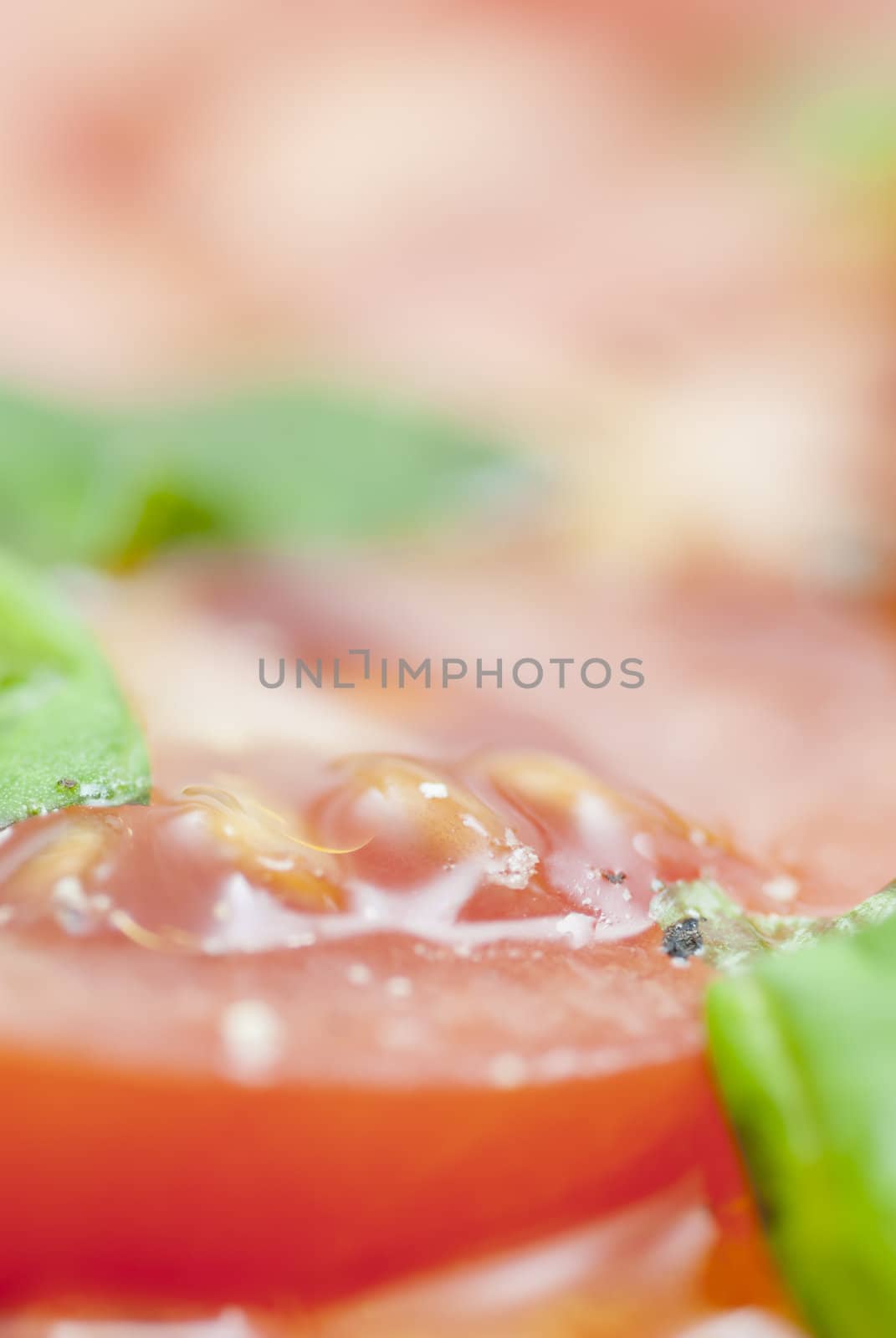 Macro image of slices of Tomato prepared with oilive oil, basil, pepper & salt.