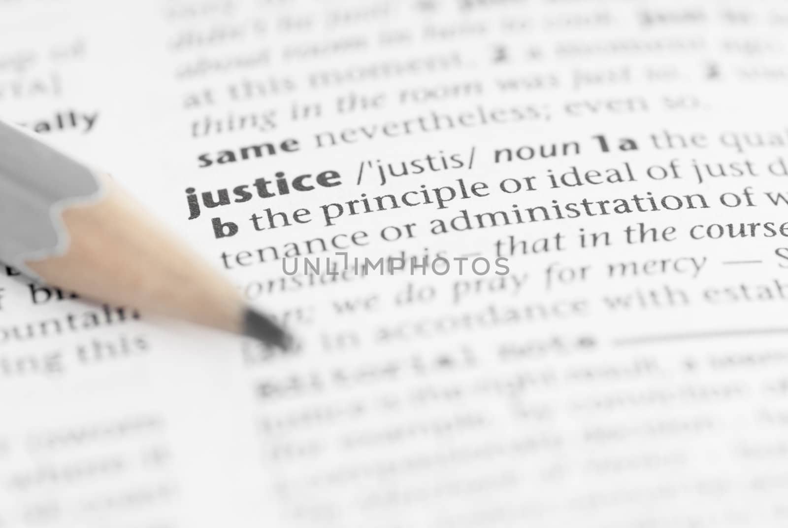 Macro image of dictionary word: Justice, and pencil.