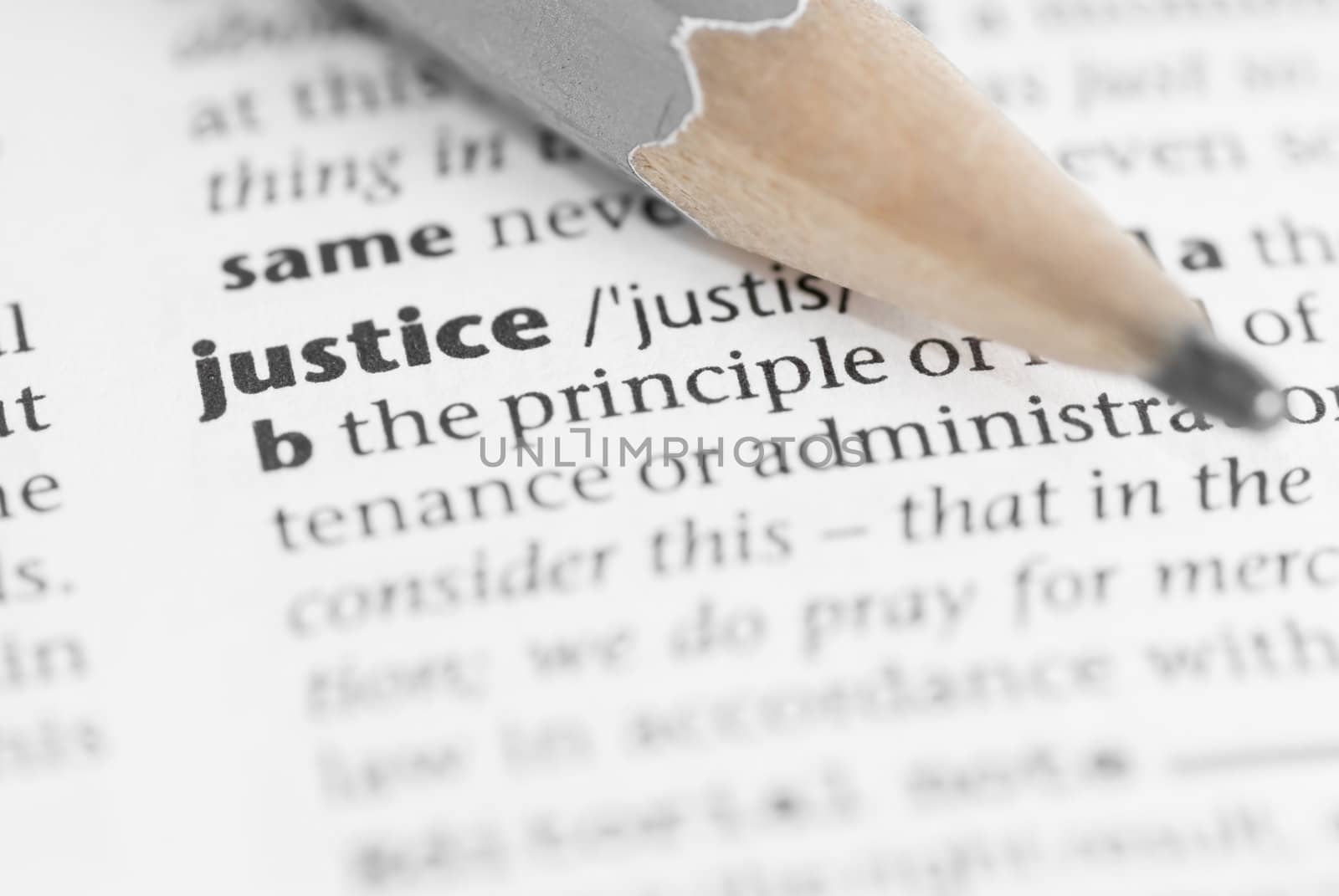 Macro image of dictionary word: Justice, and pencil.